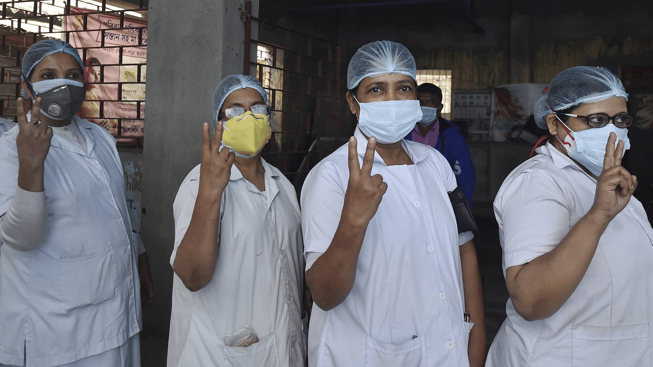  Frontline workers flash the victory sign after being inoculated with the first dose of Covishield vaccine during a countrywide Covid-19 vaccination drive, at a government hospital in Howrah district, West Bengal. Credit: PTI Photo