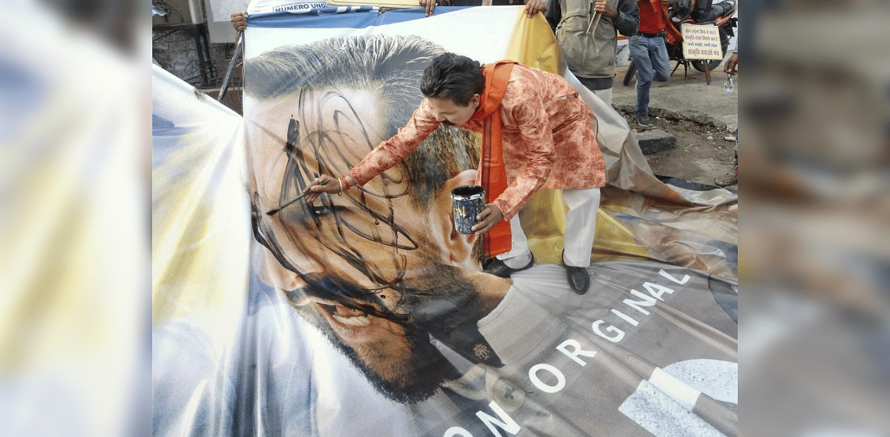 Sanskriti Bachao Manch activists smear black paint on a poster of the Amazon Prime web series 'Tandav' during a protest, in Bhopal. Credit: PTI Photo