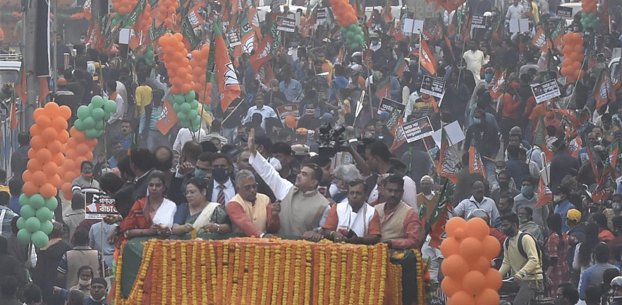 BJP leader Suvendu Adhikary wave at party activists during a roadshow from Tollygunge tram depot to Rashbehari at South Kolkata. Credit: PTI Photo