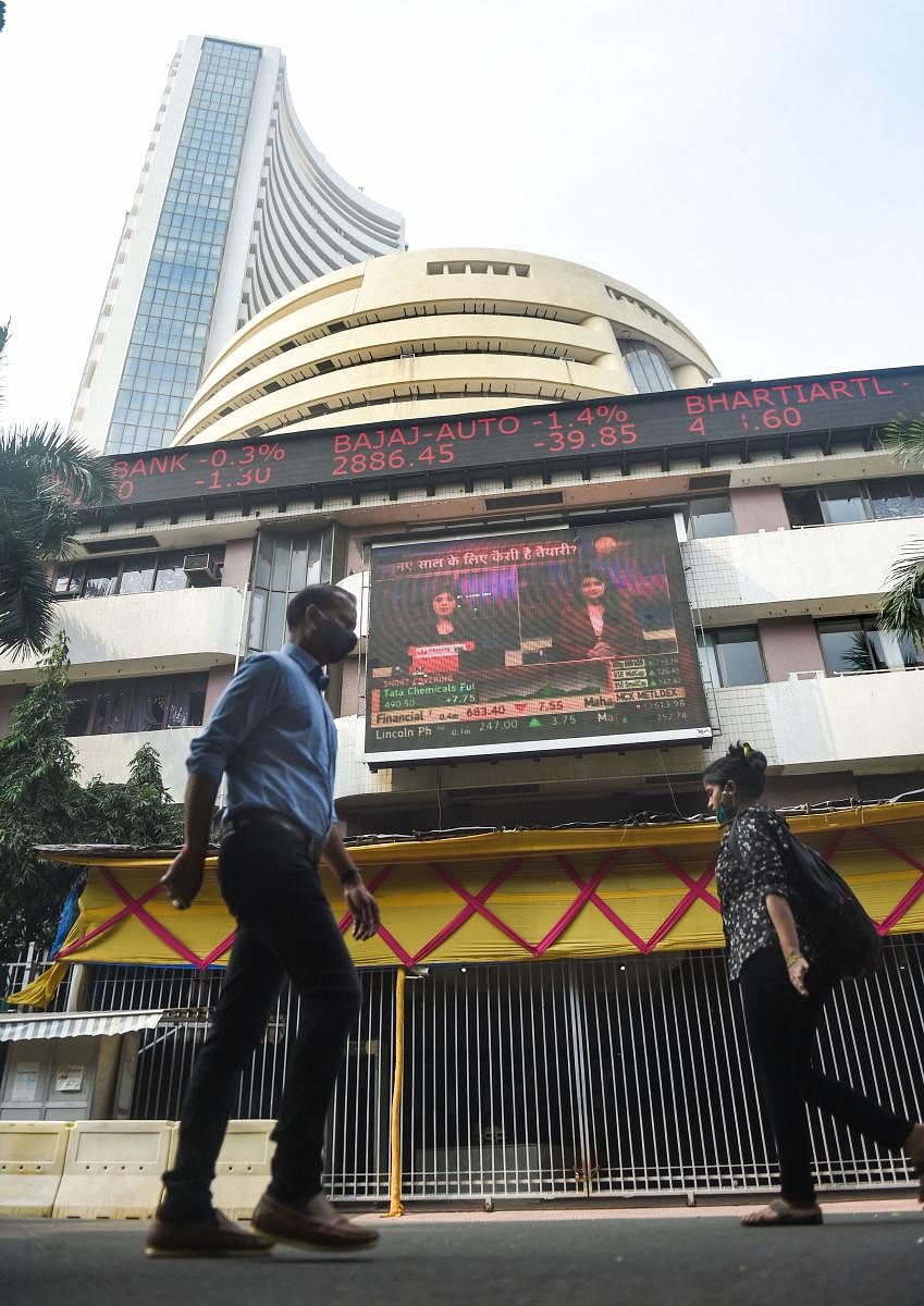 People walk in front of a digital screen at the facade of BSE, as the Sensex crossed 48000 mark for the first time, in Mumbai, Monday, Jan. 4, 2021. Credit: PTI Photo