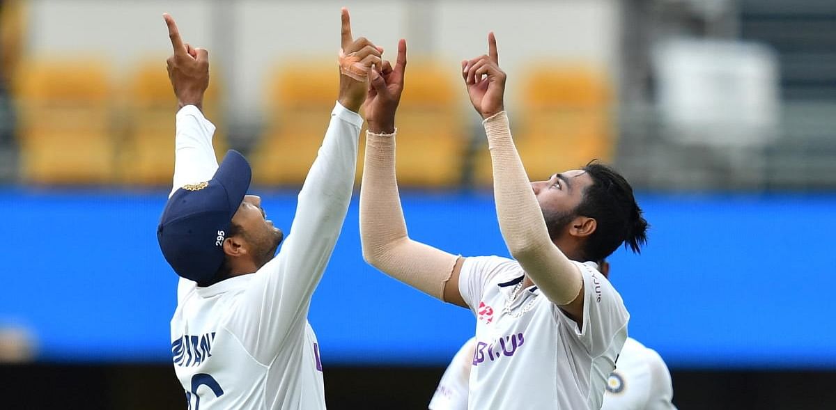 Mohammed Siraj of India celebrates with Mayank Agarwal after getting the wicket of Josh Hazlewood of Australia during day four of the fourth test match between Australia and India at the Gabba in Brisbane, Australia, January 18, 2021. Credit: AFP Photo