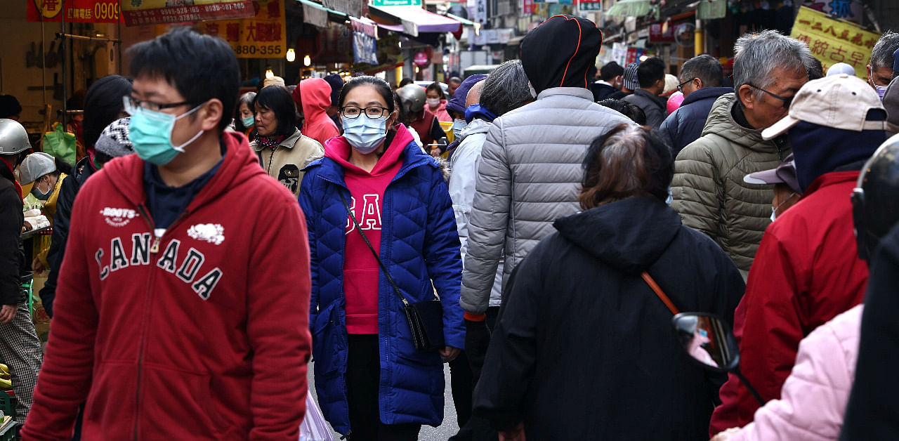 Customers wear protective masks to prevent the spread of the Covid-19 while shopping at a market in Taipei. Credit: Reuters Photo
