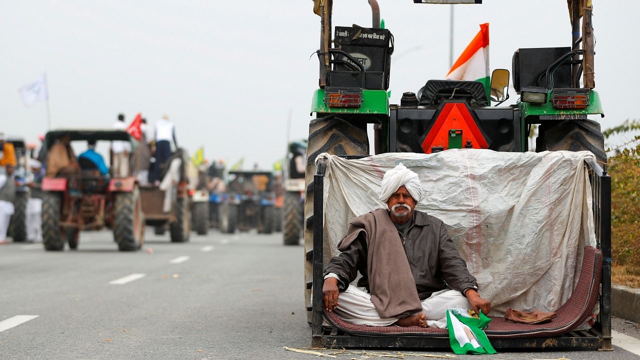 A farmer rests during a tractor rally to protest against the newly passed farm bills, on a highway on the outskirts of New Delhi, India, January 7, 2021. Credit: Reuters Photo