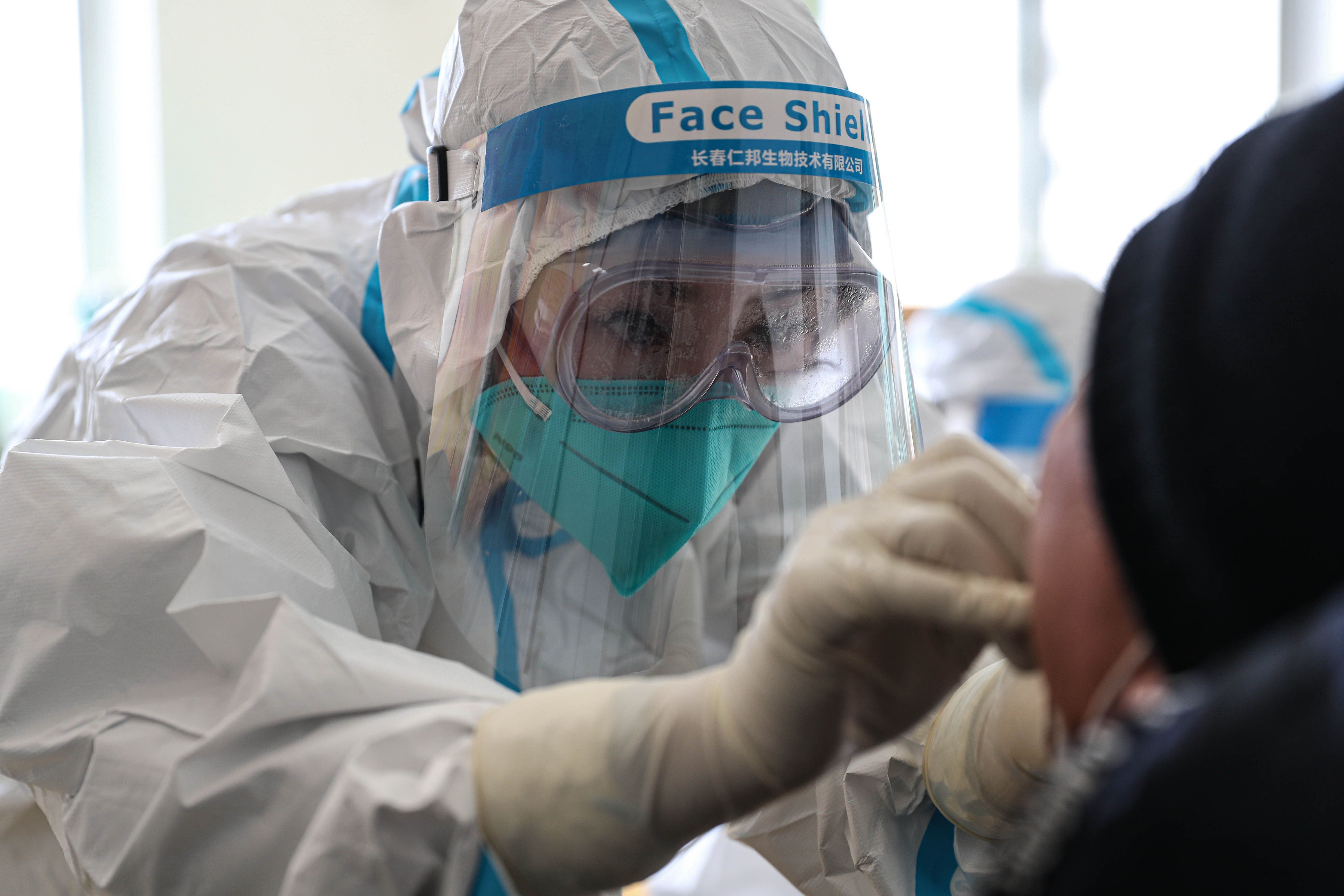 A medical worker takes a swab sample from a resident to test for the COVID-19 coronavirus in Shenyang, in China's northeast Liaoning province. Credit: AFP File Photo