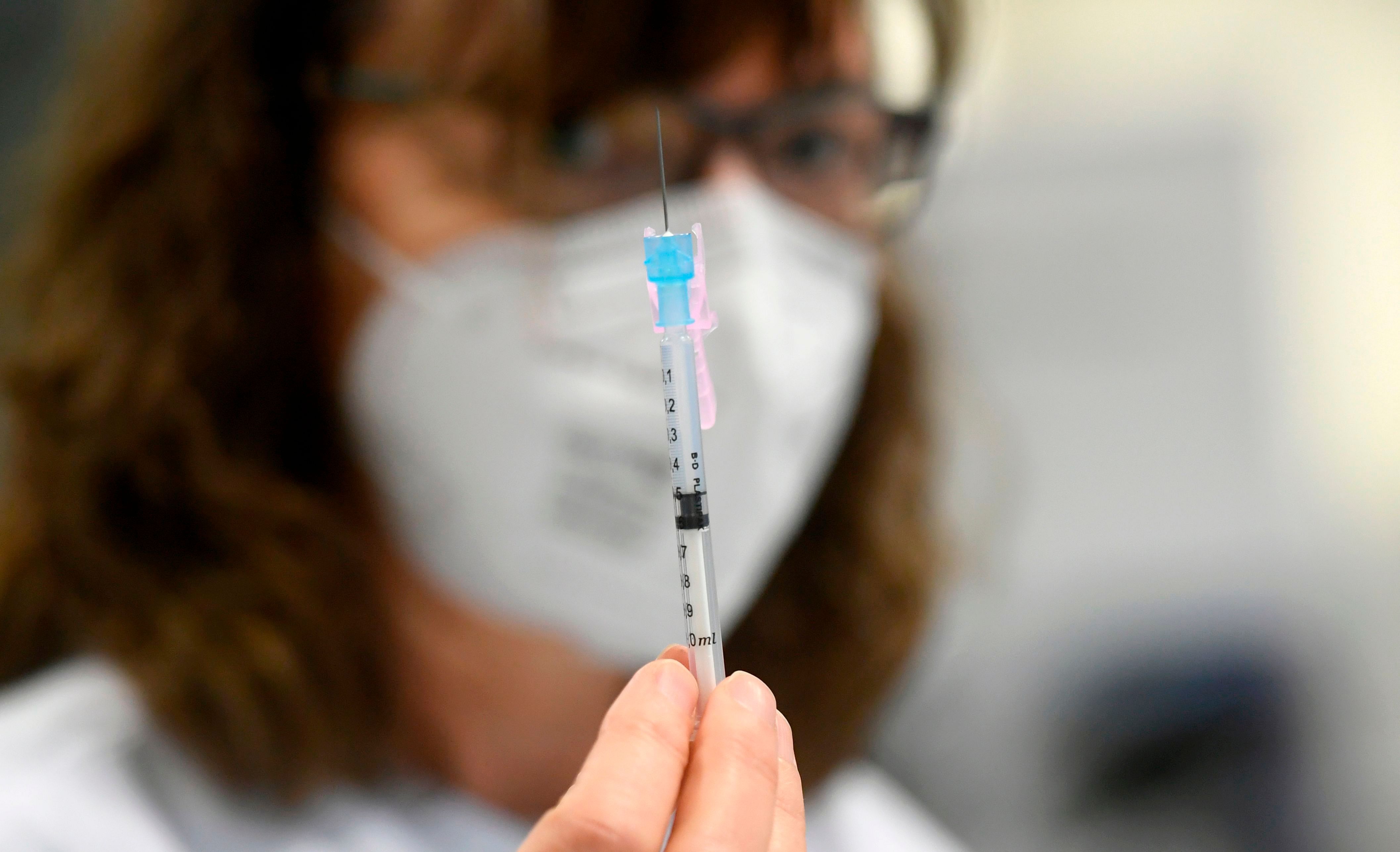 An employee presents an injection with the Moderna Covid-19 vaccine at the corona vaccination centre at the University hospital in Essen, western Germany, on January 18, 2021. - The European Union began a vaccine rollout, even as countries in the bloc were forced back into lockdown by a new strain of the virus, believed to be more infectious, that continues to spread from Britain. The pandemic has claimed more than 1.7 million lives and is still running rampant in much of the world, but the recent launching of innoculation campaigns has boosted hopes that 2021 could bring a respite. Credit: AFP