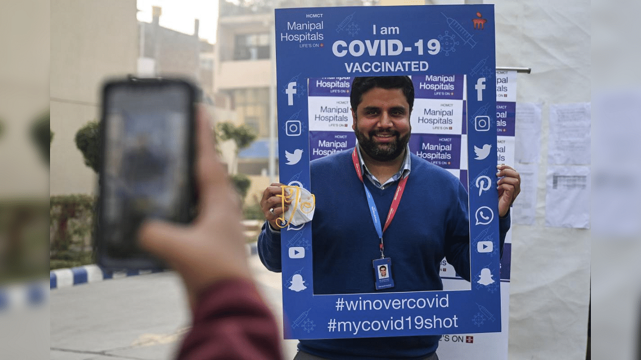 A hospital staff gets his photo clicked by a colleague after getting a Covid-19 coronavirus vaccine at the Manipal Hospital, in New Delhi on January 19, 2021. Credit: AFP Photo