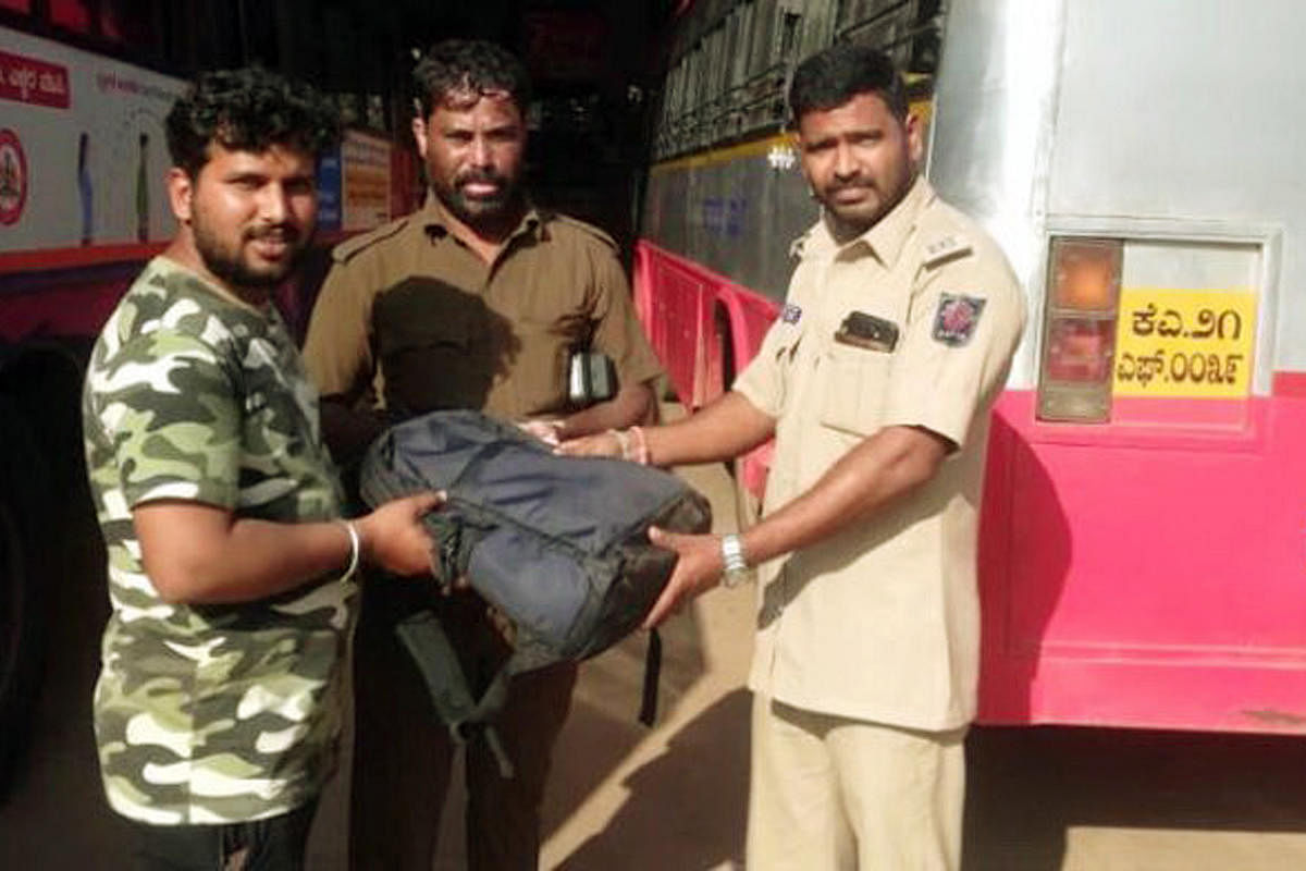 KSRTC driver Isub Ali and conductor Manju hand over a bag with a laptop to its owner at KSRTC Bus Stand in Subrahmanya.