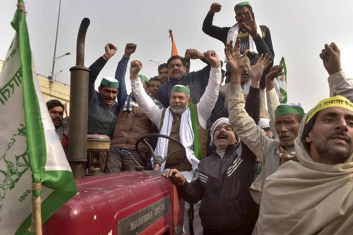 BKU spokesperson Rakesh Tikiat along with farmers raises slogans during their ongoing agitation against Centre's farm reform laws at Ghazipur border, in New Delhi, Tuesday, Jan. 19, 2021. Credit: PTI Photo