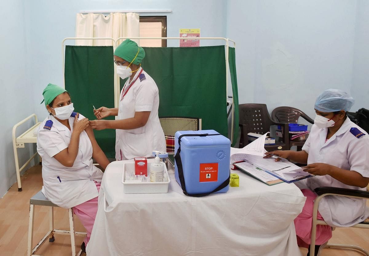 A medic vaccinates a healthworker with Covishield vaccine during a countrywide inoculation drive against COVID-19, at Rajawadi Municipal Hospital in Mumbai, Tuesday, Jan. 19, 2021. Credit: PTI Photo