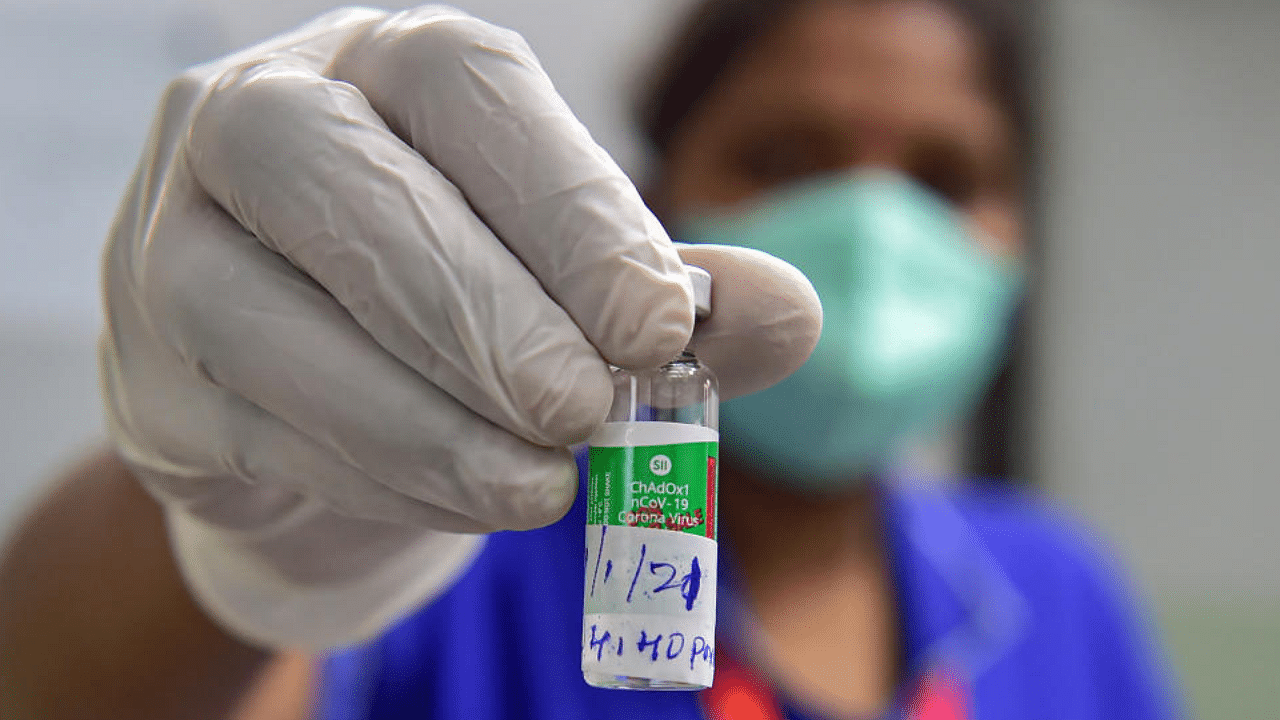 A medic shows a vial of COVID vaccine as she prepares to administer it to a medical student during the first phase of the countrywide inoculation drive, in Bengaluru, Tuesday, Jan. 19, 2021. Credit: PTI Photo