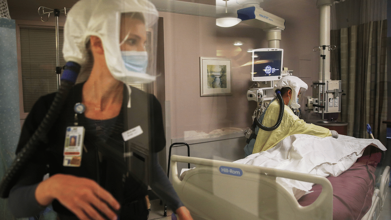 Registered nurses Lindsey Ryan (L) and Carrie Tang provide post-mortem care to a deceased COVID-19 patient in the Intensive Care Unit at Sharp Grossmont Hospital on December 14, 2020 in La Mesa, California. Credit: AFP Photo
