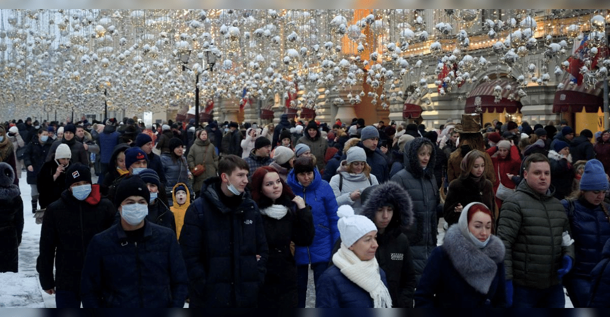 People, some of them wearing a protective face mask walk in central Moscow. Credit: AFP Photo