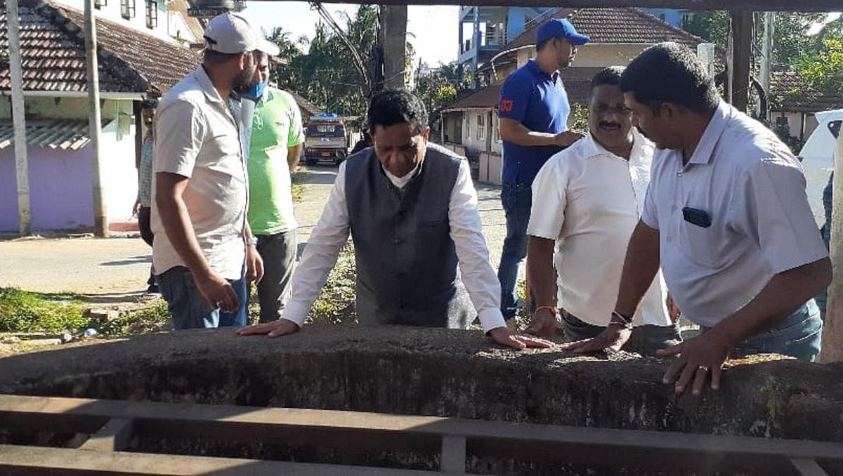 MLA K G Bopaiah inspects an open well near Shantha Theatre on Appayya Swamy Road.