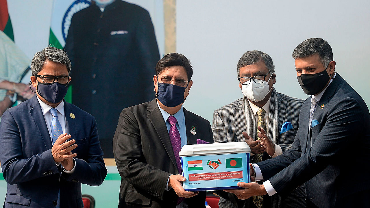 Indian high commissioner of Bangladesh Vikram Doraiswami (R), Bangladesh's Foreign Minister AK Abdul Momen (2L) and Bangladesh's health minister Zahid Maleque (2R) pose for pictures during a handover ceremony of 2 million doses of the Oxford-AstraZeneca vaccine manufactured by the Serum Institute of India, in Dhaka. Credit: AFP Photo