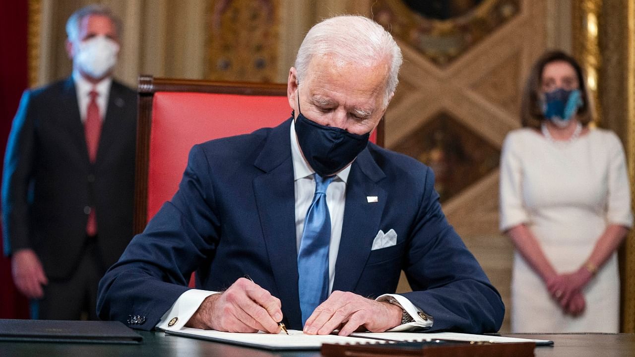President Joe Biden signs three documents including an inauguration declaration, cabinet nominations and sub-cabinet nominations in the President's Room at the US Capitol after the inauguration ceremony. Credit: AP/PTI Photo
