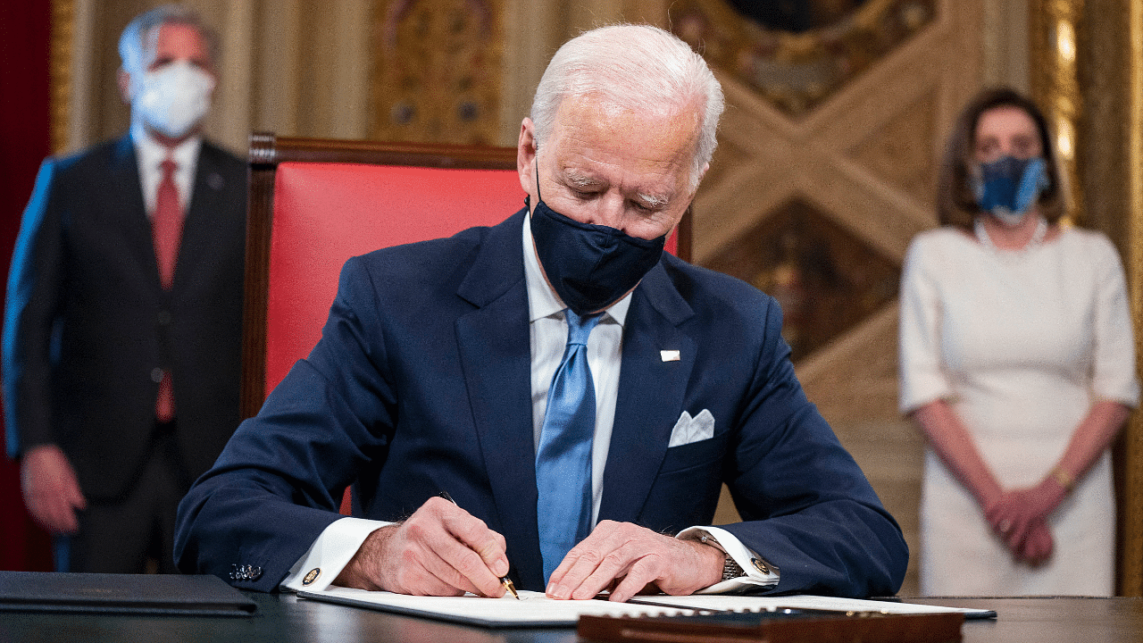 President Joe Biden signs three documents including an inauguration declaration, cabinet nominations and sub-cabinet nominations in the President's Room at the US Capitol after the inauguration ceremony. Credit: AP/PTI Photo