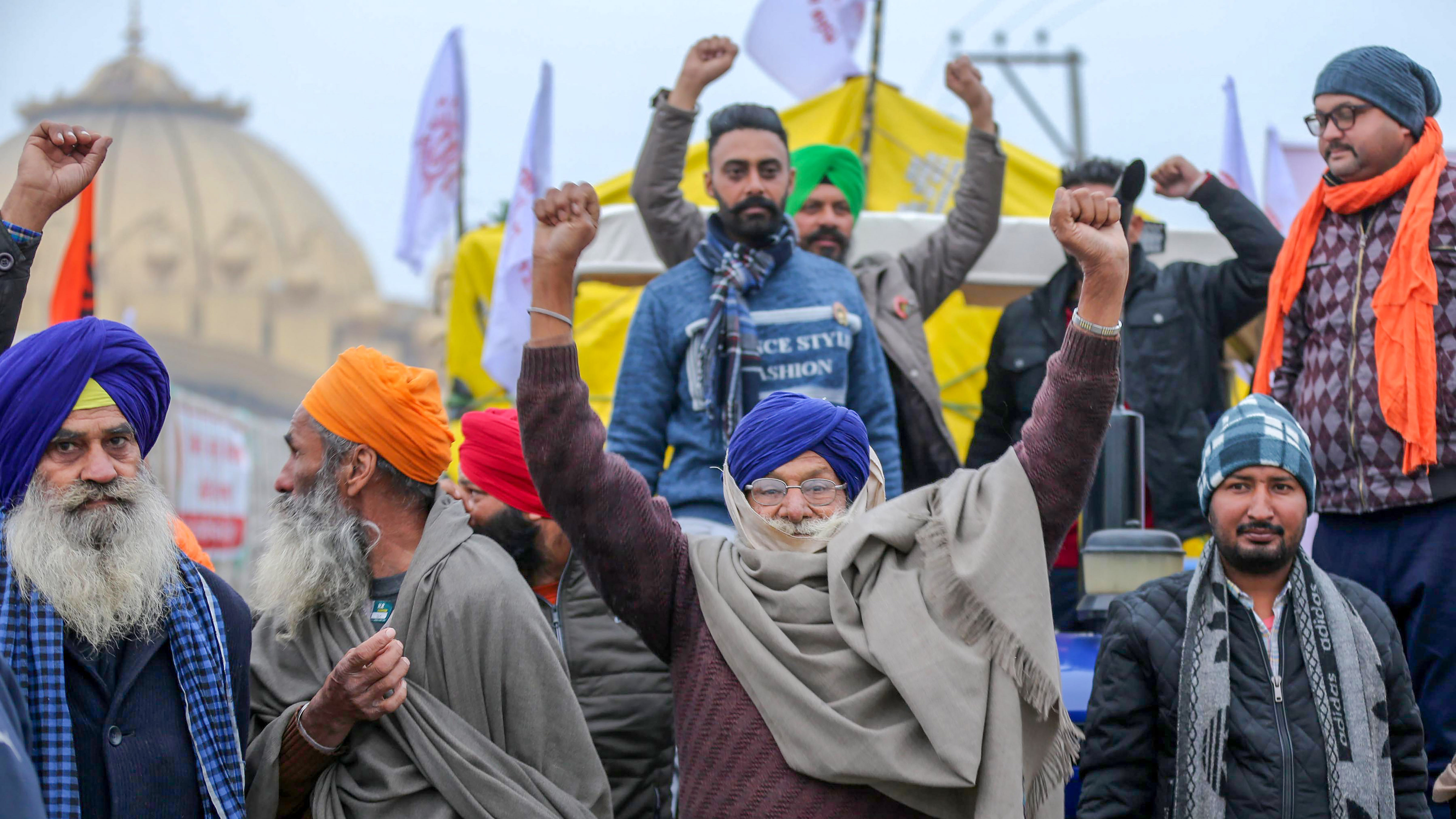Farmers raise slogans as they march towards Delhi on their tractors, to join the main agitation against the Center's farm laws, in Amritsar. Credit: PTI