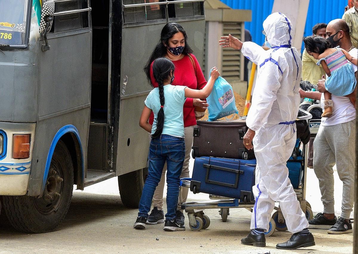 A health worker guides passengers to a quarantine centre on their arrival from the United Kingdom, at the Chennai International Airpor, in Chennai, Tuesday, Dec. 22, 2020. Indian government has temporarily suspended all passengers' flights from the United Kingdom in the wake the new COVID-19 strain found in the country. Credit: PTI File Photo