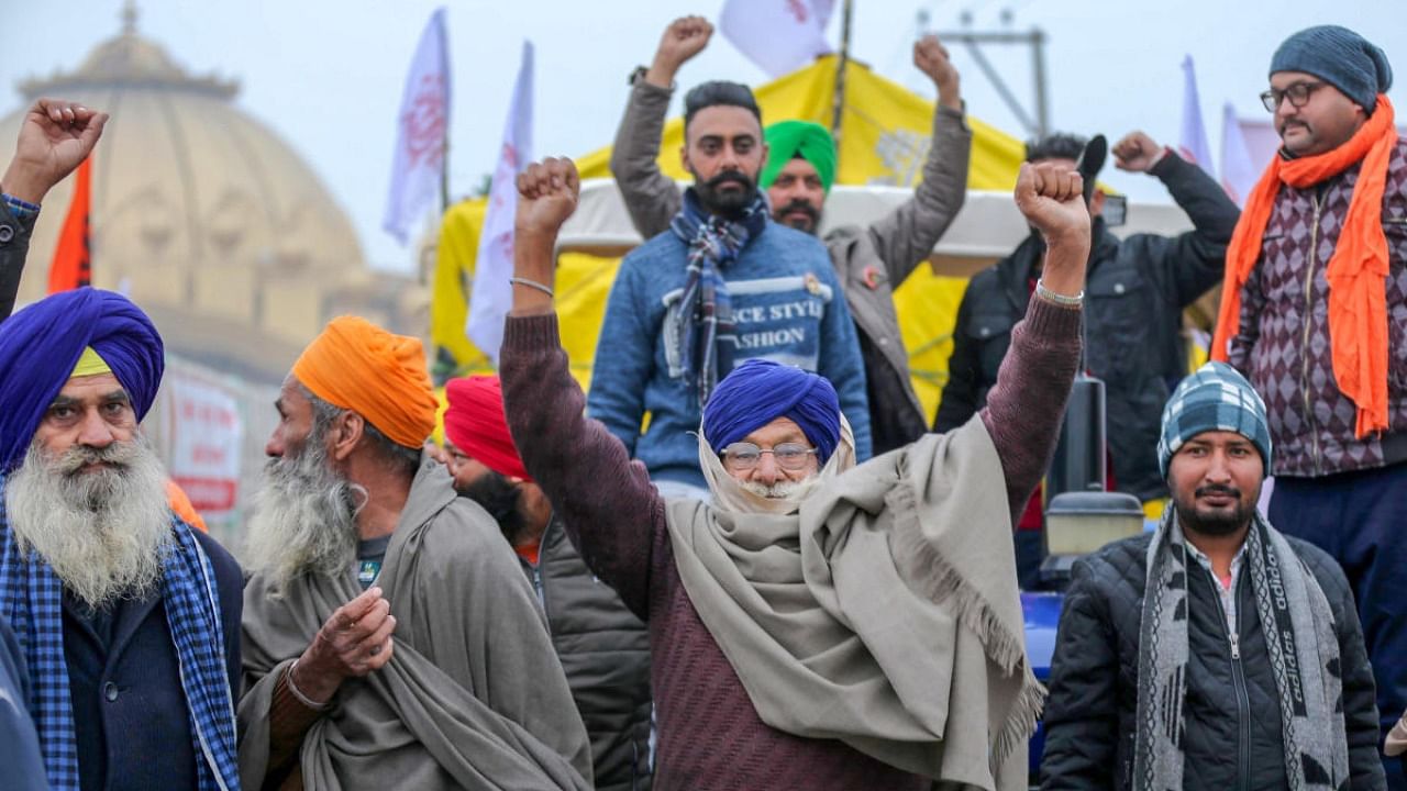 Farmers raise slogans as they march towards Delhi on their tractors, to join the main agitation against the Center's farm laws, in Amritsar. Credit: PTI Photo