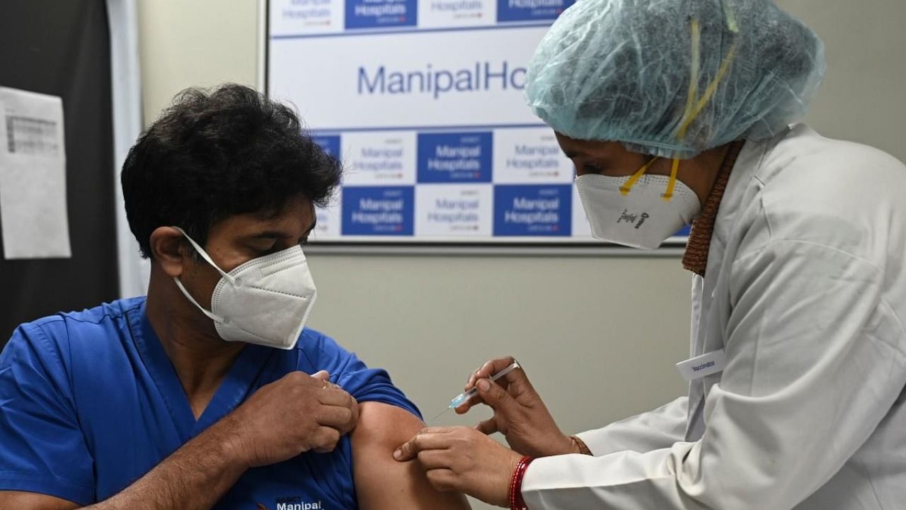 A medical worker (R) inoculates a medical staff with a Covid-19 coronavirus vaccine at the Manipal Hospital, in New Delhi on January 19, 2021. Credit: AFP Photo