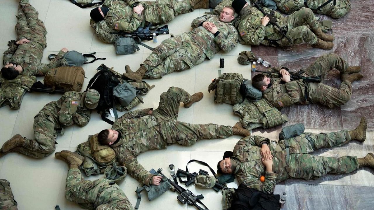 In this file photo taken on January 13, 2021, members of the National Guard rest in the Capitol Visitors Center on Capitol Hill in Washington, DC. Credit: AFP Photo