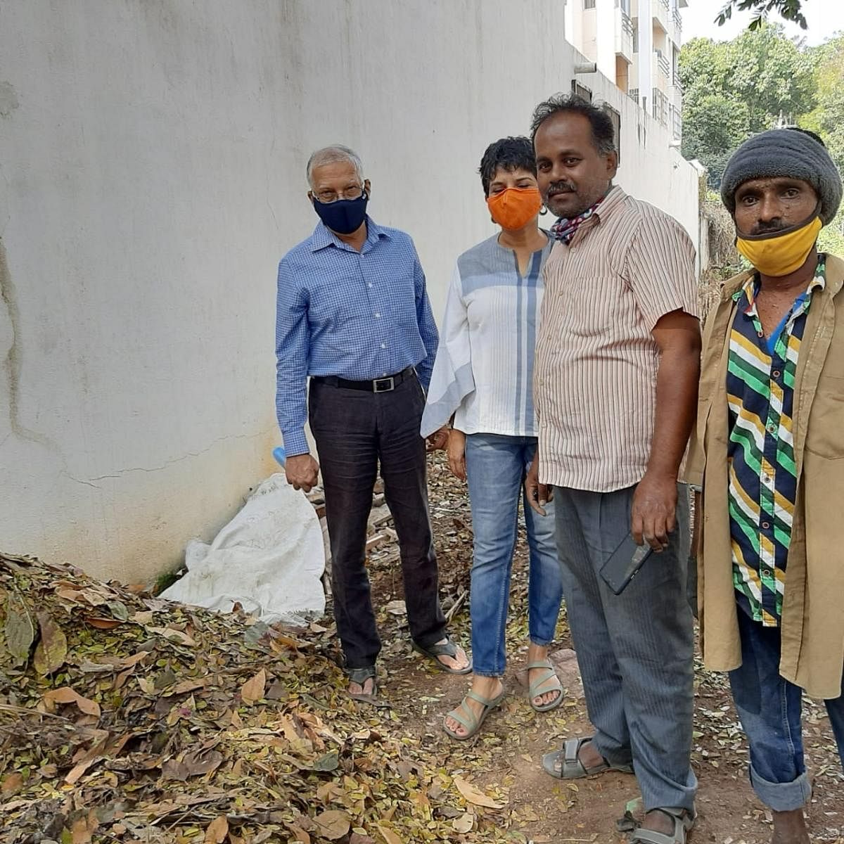 Members of the Richards Town Welfare Association KG Shashidhar (left) and Monisha Lobo with BBMP workers at the segregation and packaging site for dry leaves.