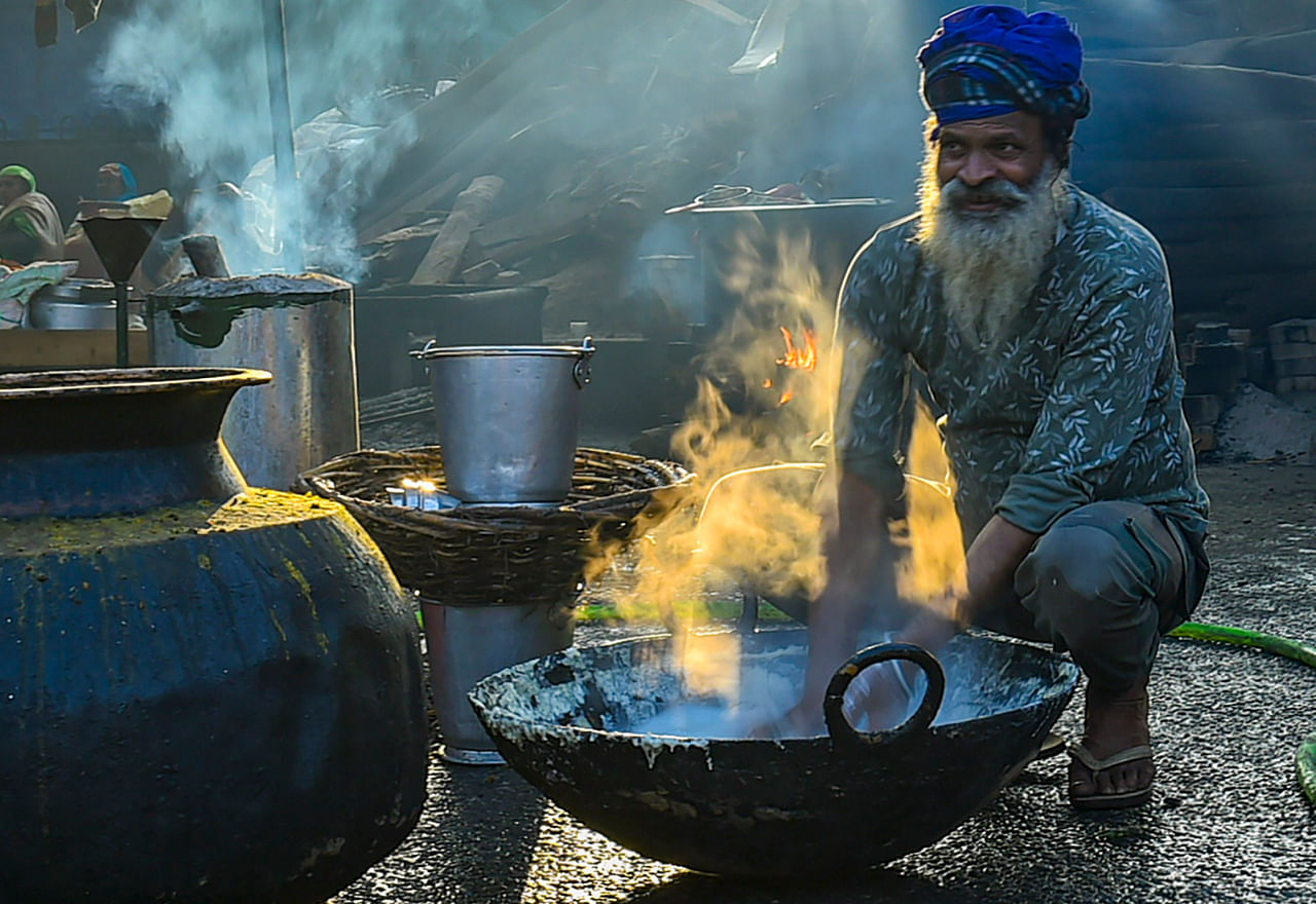 A farmer prepares food for fellow farmers during a protest against the new farm laws, at Singhu border in New Delhi, Saturday, Jan. 16, 2021. Credit: PTI Photo