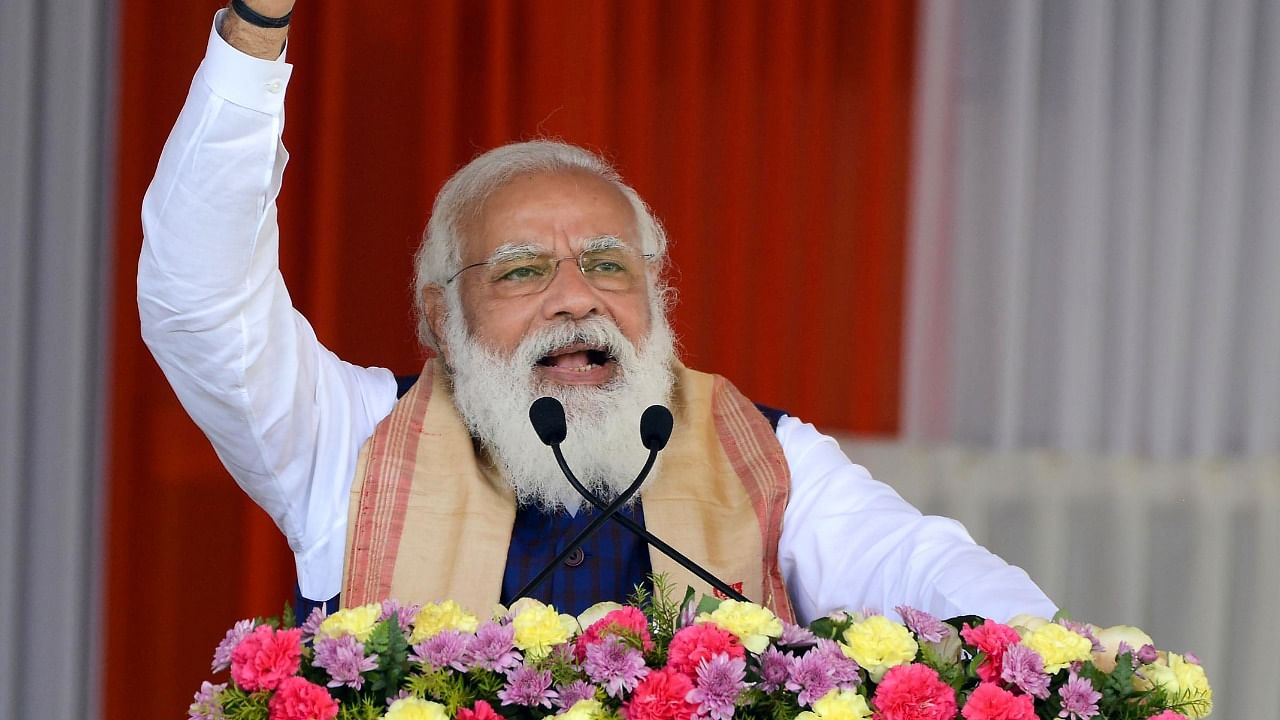 Prime Minister Narendra Modi delivers a speech after distributing 'Land Patta' to people during a public meeting, at Jerenga Pathar in Sivasagar District of Assam,. Credit: PTI Photo