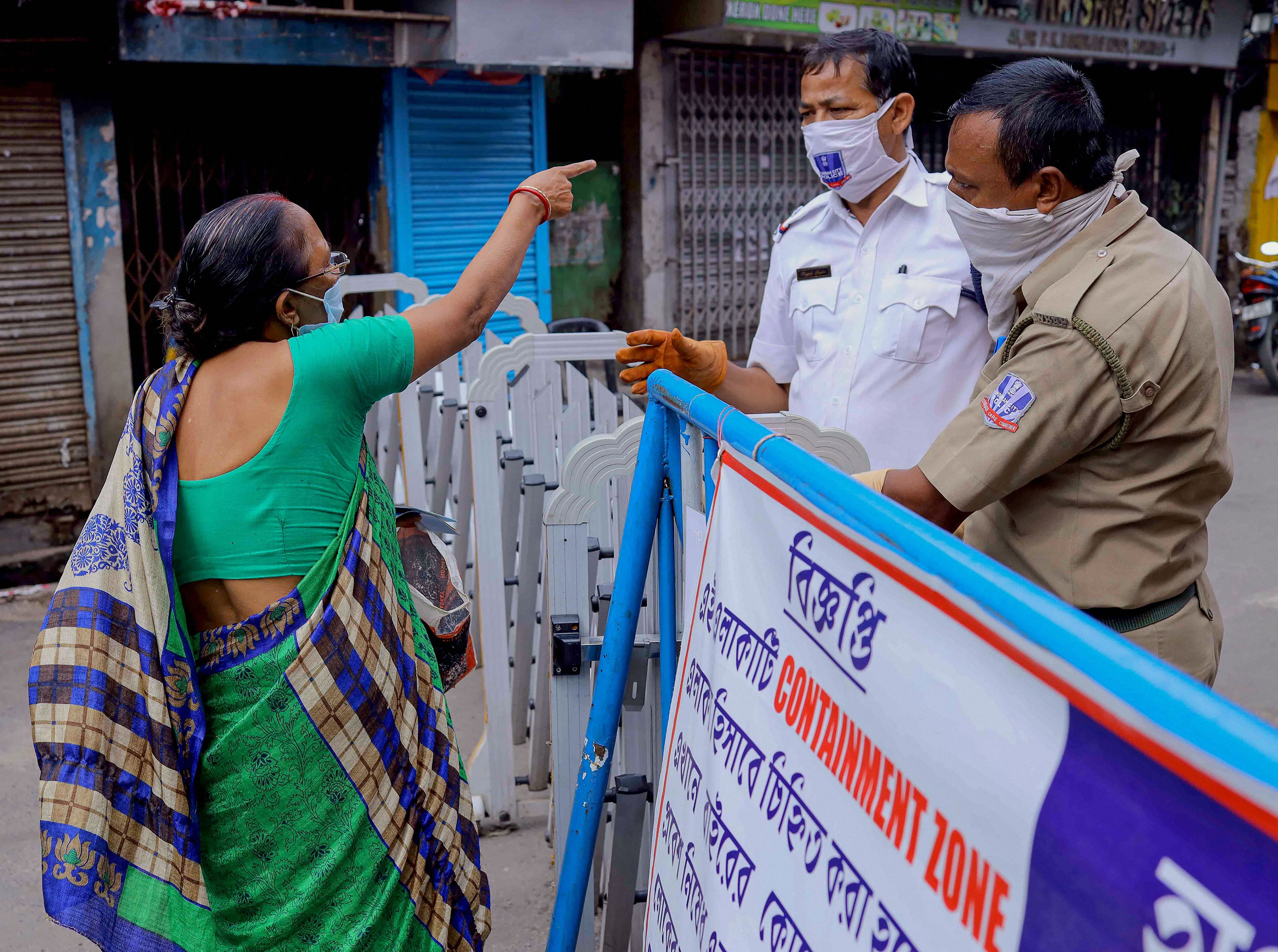 Policemen stop a commuter from entering at sealed residential area after the state government imposed total lockdown in all containment zones follwing a surge in Covid-19 cases, in Howrah, Monday, July 13, 2020. Credit: PTI File Photo