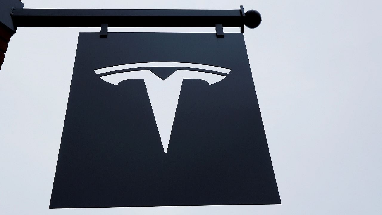 A Tesla logo hang on a building outside of a Tesla dealership in New York. Credit: Reuters Photo