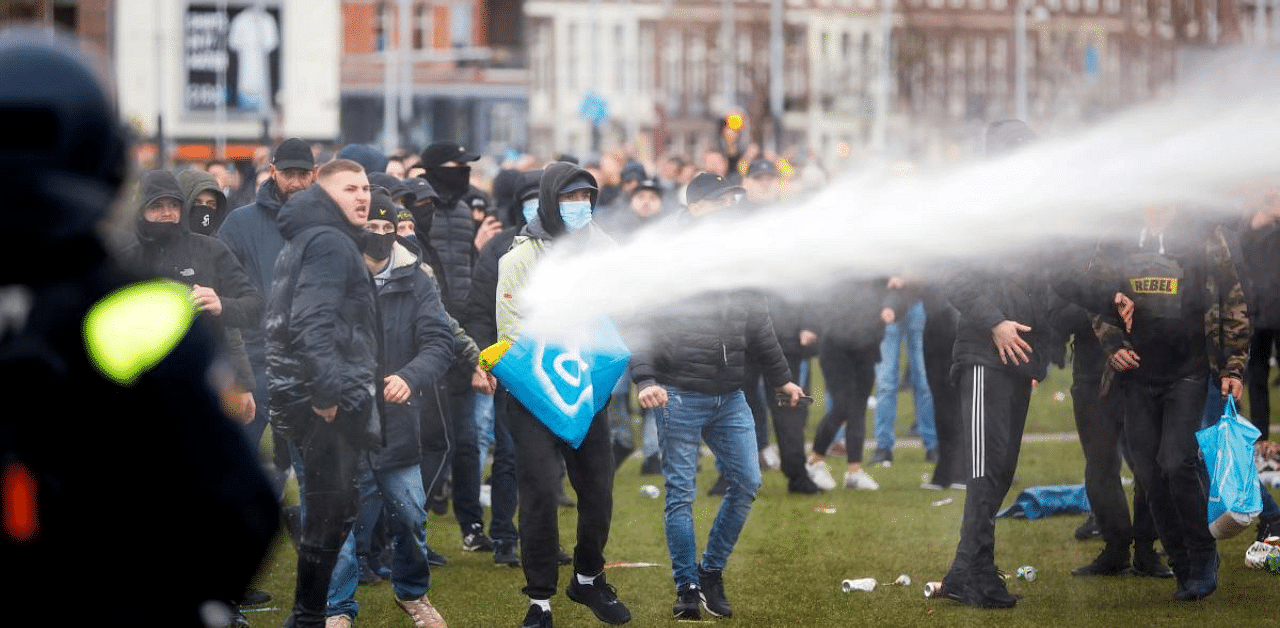 Demonstrators are sprayed by police water cannon at Amsterdam's Museumplein during a protest against the lockdown imposed to curb the spread of the Covid-19 pandemic and the outgoing government's policy, Credit: AFP Photo