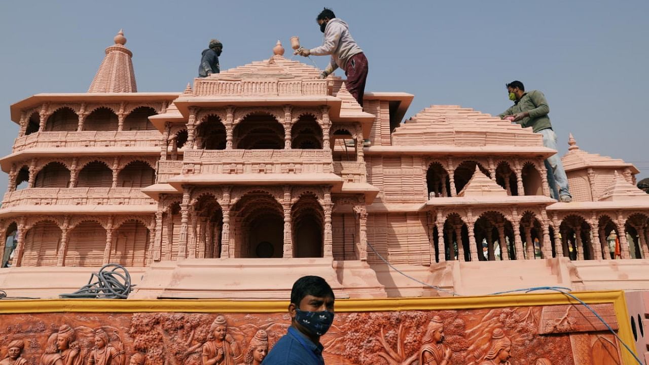 Workers give finishing touches to the model of the proposed Ram temple that Hindu groups want to build at a religious site in Ayodhya, on a tableau during a media preview of tableaux participating in the Republic Day parade in New Delhi. Credit: Reuters Photo