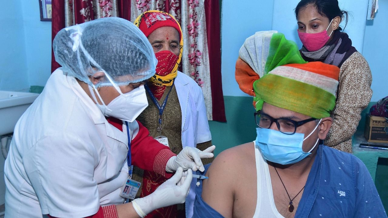 A medic administers the first dose of Covishield vaccine on frontline worker Pawan Saraswat, at a city dispensary in Bikaner. Credit: PTI File Photo