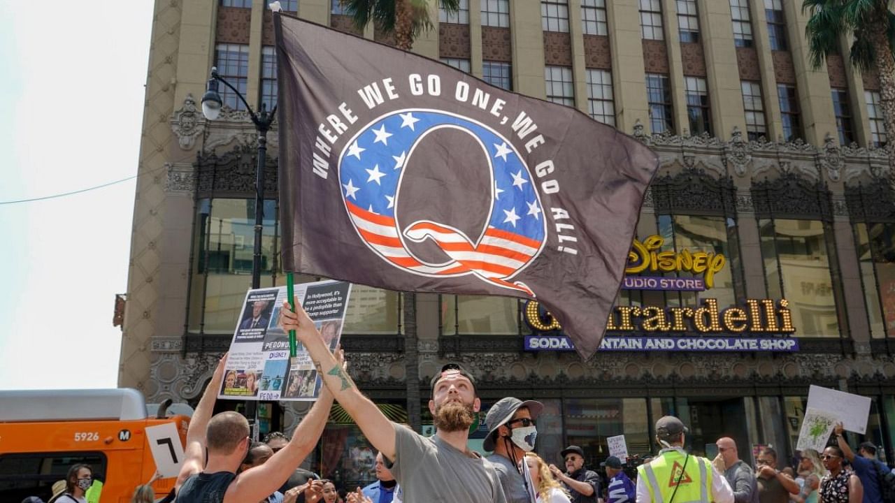 In this file photo taken on August 22, 2020, conspiracy theorist QAnon demonstrators protest child trafficking, on Hollywood Boulevard in Los Angeles. Credit: AFP file photo.