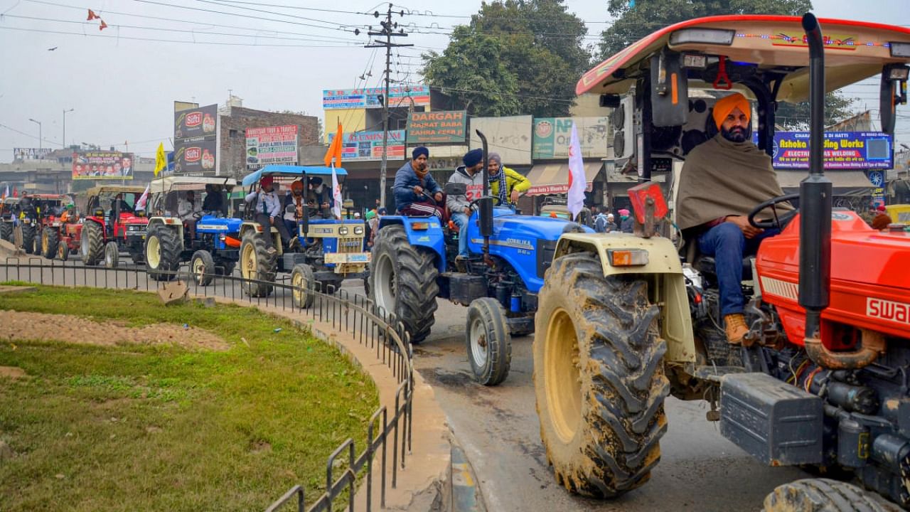 Farmers take out a tractor march as part of the preparations for their planned tractor parade in the national capital on Republic day, during a protest against the new farm laws, in Amritsar. Credit: PTI.