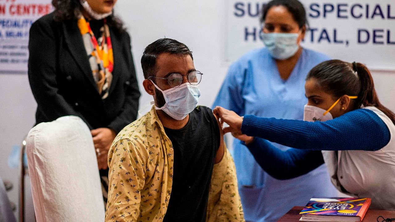 A medical worker (R) inoculates a colleague with a Covid-19 coronavirus vaccine at the Rajiv Gandhi Super Speciality Hospital in New Delhi on January 18, 2021. Credit: AFP Photo