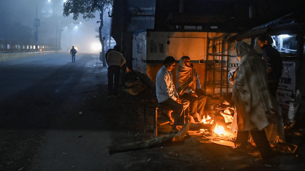  People sit near a bonfire to warm themselves during a cold winter morning, in Ghaziabad, Friday, Jan. 22, 2021. Credit: PTI Photo