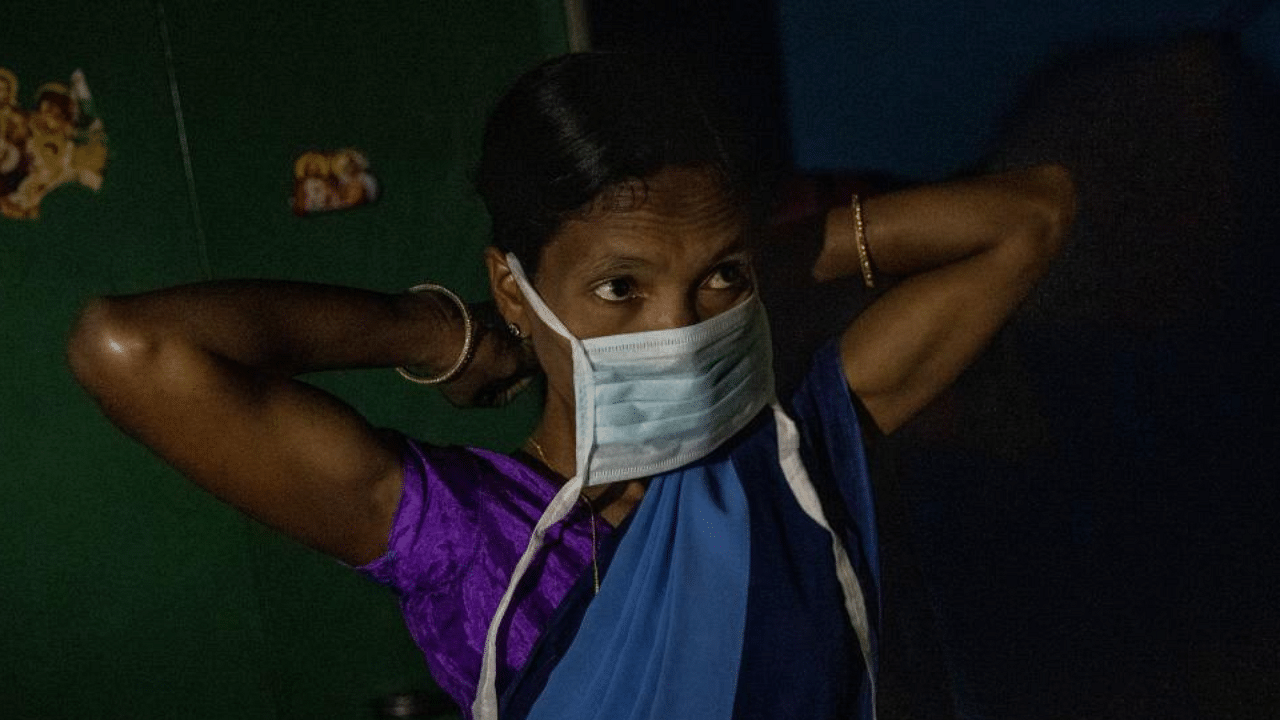 Reena Jani, 34, a health worker, puts on a protective face mask as she gets ready to travel to Mathalput Community Health Centre to receive the vaccine developed by Oxford/AstraZeneca, during the coronavirus disease (COVID-19) pandemic, in Pendajam village in Koraput, India, January 16, 2021. Credit: Reuters Photo