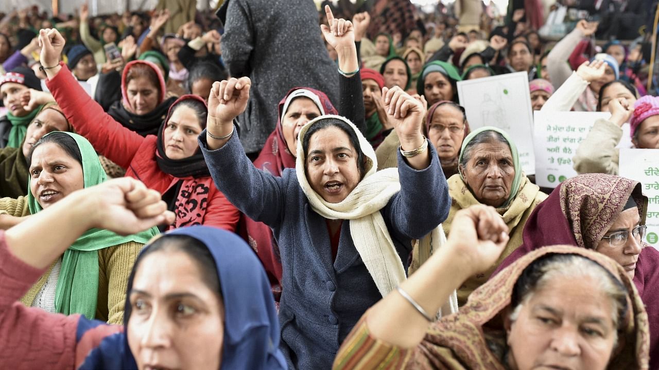 Women raise slogans during farmers' protest against new farm laws, at the Singhu Border in New Delhi. Credit: PTI Photo