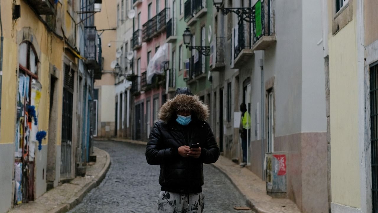 A person wearing a protective mask walks in Bairro Alto neighborhood during the national lockdown, amid the coronavirus disease (Covid-19) pandemic, in Lisbon, Portugal. Credit: Reuters Photo