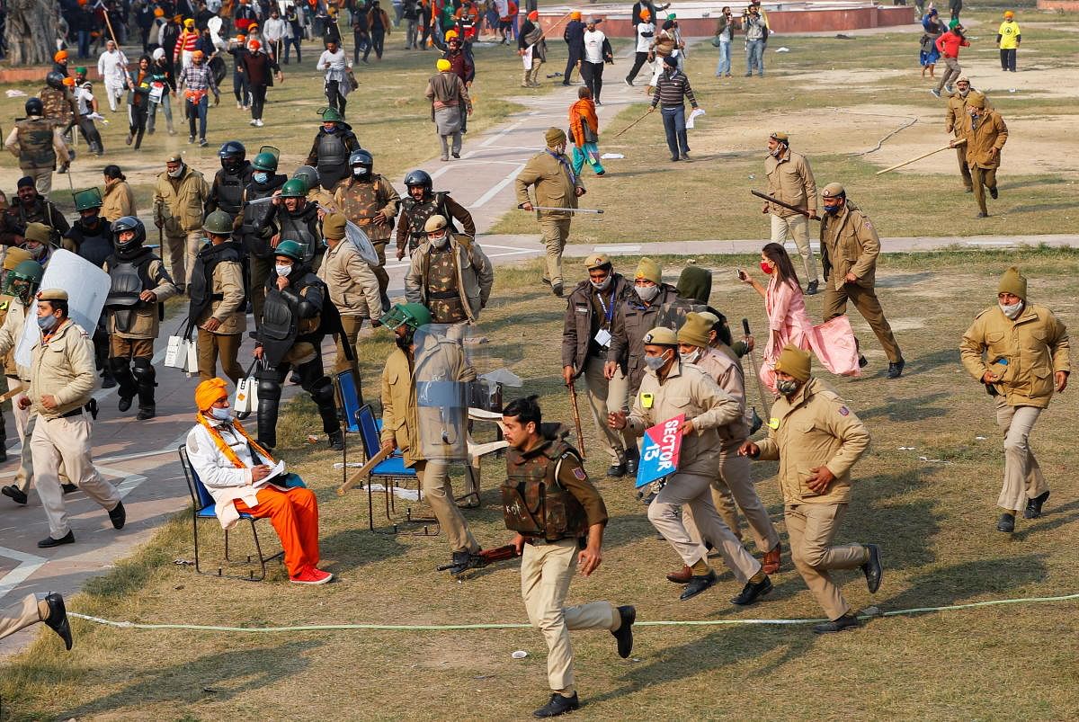 Police officers run during a protest of farmers against farm laws introduced by the government, at the historic Red Fort in Delhi, India, January 26, 2021. Credit: REUTERS