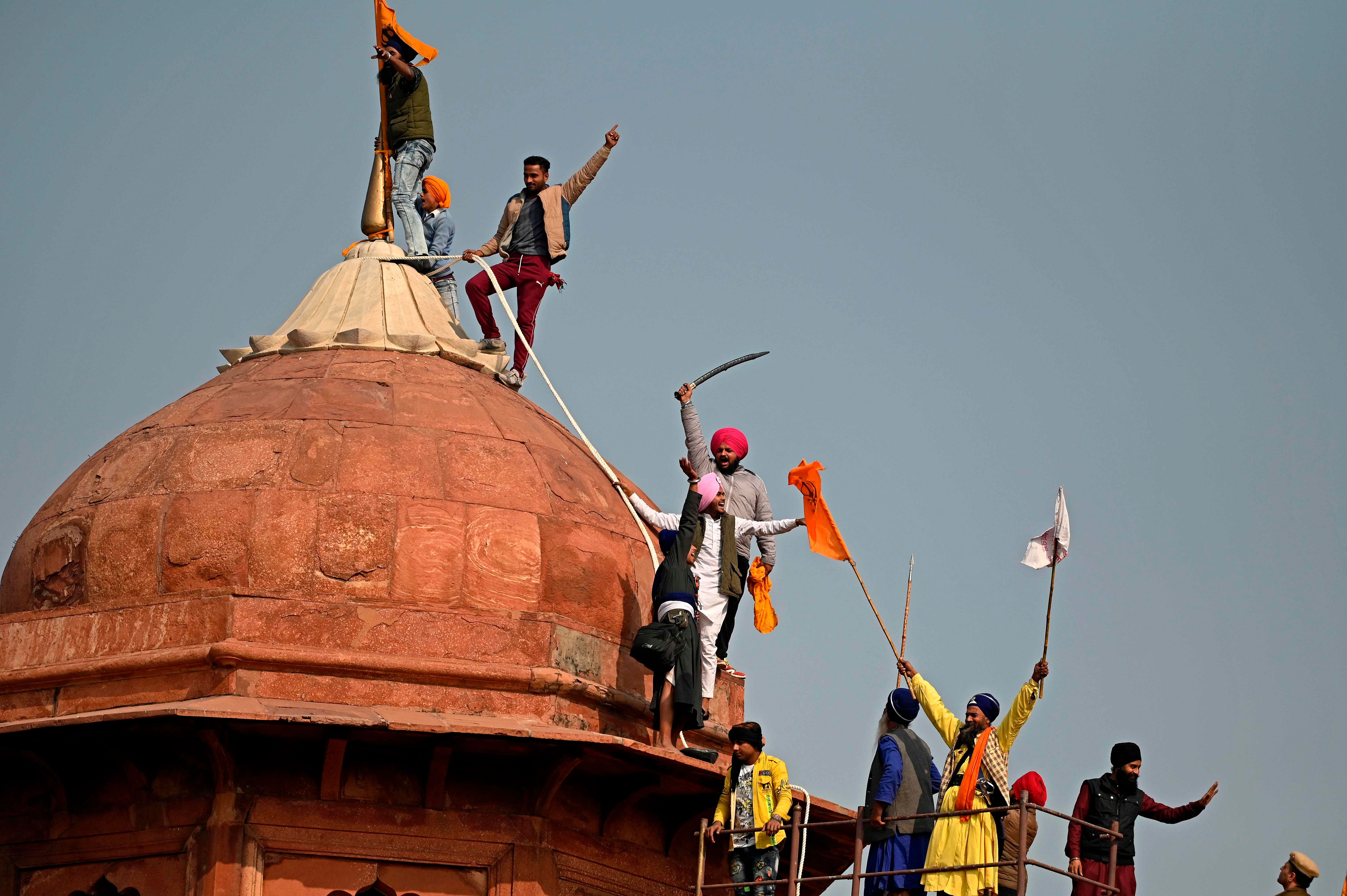 Protesters climb on a dome at the ramparts of the Red Fort as farmers continue to demonstrate against the central government's recent agricultural reforms in New Delhi. Credit: AFP Photo