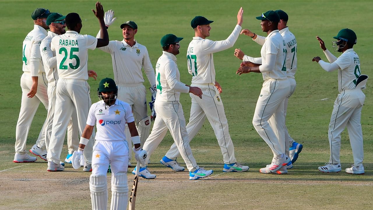 South Africa's players celebrate after the dismissal of Pakistan's Imran Butt (front) during the first day of the first cricket Test match between Pakistan and South Africa at the National Stadium in Karachi on January 26, 2021. Credit: AFP Photo