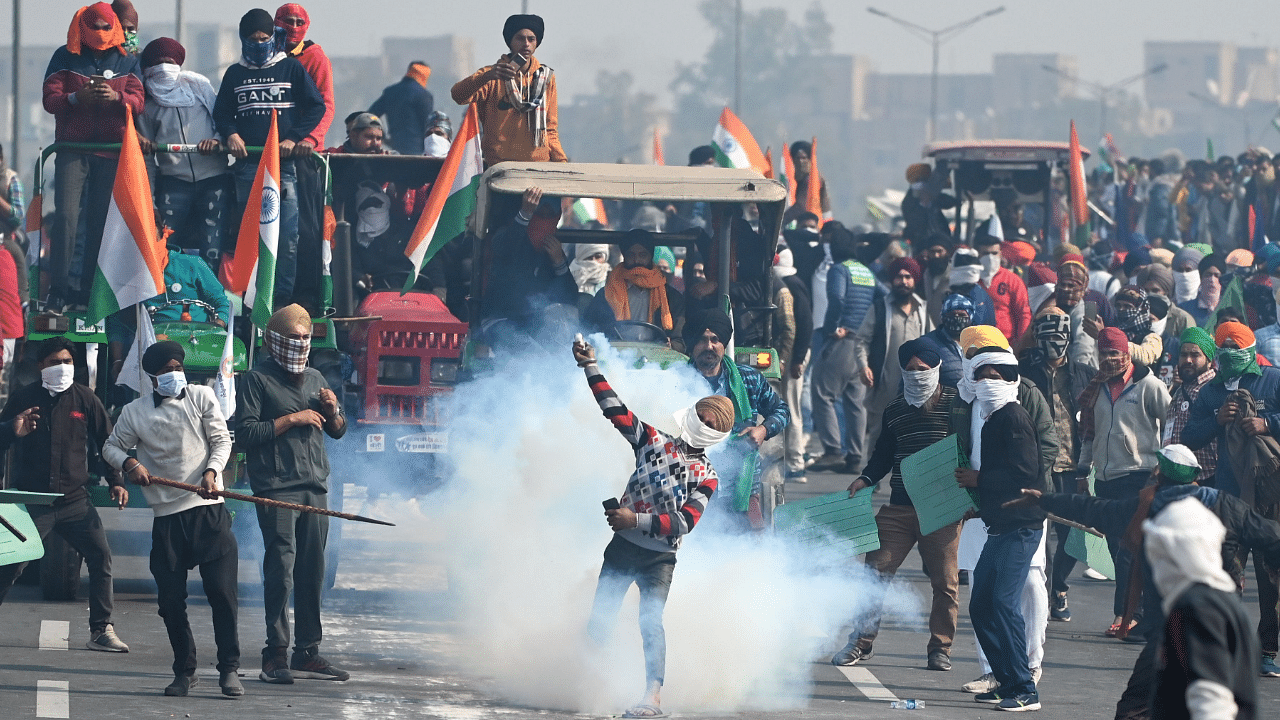 A farmer throws back a tear gas shell fired by the police to disperse them during a tractor rally as farmers continue to demonstrate against the central government's recent agricultural reforms in New Delhi. Credit: AFP Photo