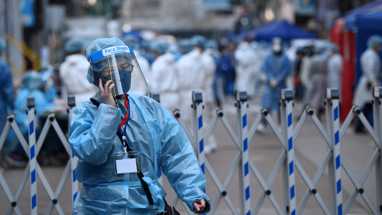 A health worker uses her phone as authorities conduct testing in the Jordan area of Hong Kong. Credit: AFP Photo