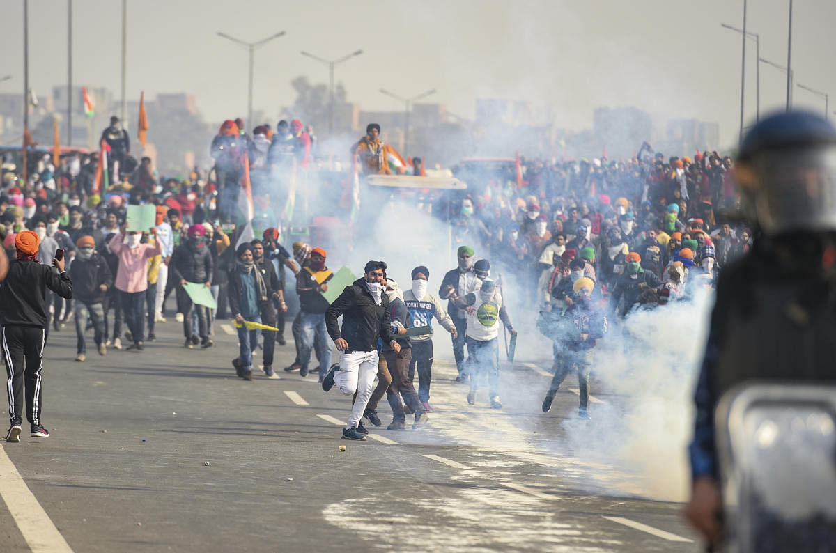 Police uses tear gas to disperse farmers attempting to break barricades at Ghazipur border during their 'Kisan Gantantra Parade', on the occasion of 72nd Republic Day, in New Delhi, Tuesday, Jan. 26, 2021. Credit: PTI Photo