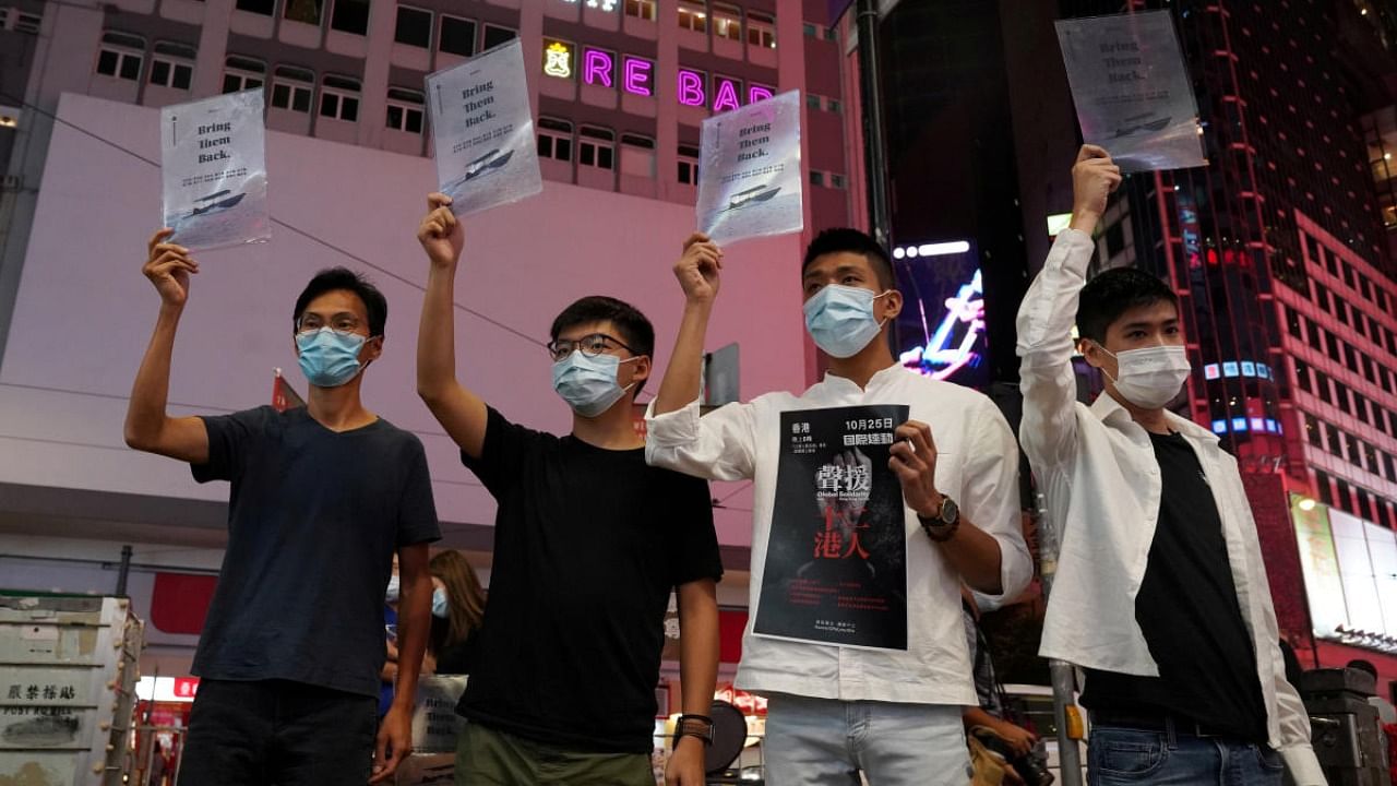 Activists Eddie Chu, Joshua Wong, Owen Chow and Lester Shum pose with signs in support of the 12 Hong Kong activists held in mainland China after attempting to flee the city for Taiwan, in Hong Kong. Credit: Reuters file photo.