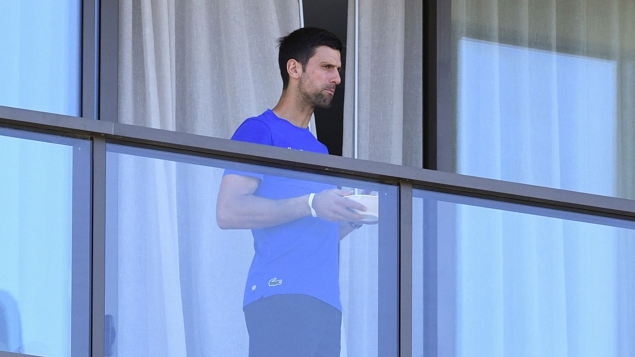 Tennis player Novak Djokovic is seen on a balcony of the M Suites hotel where tennis players are undergoing mandatory quarantine in advance of the Australian Open to be played in Melbourne, in Adelaide, Australia. Credit: Reuters File Photo