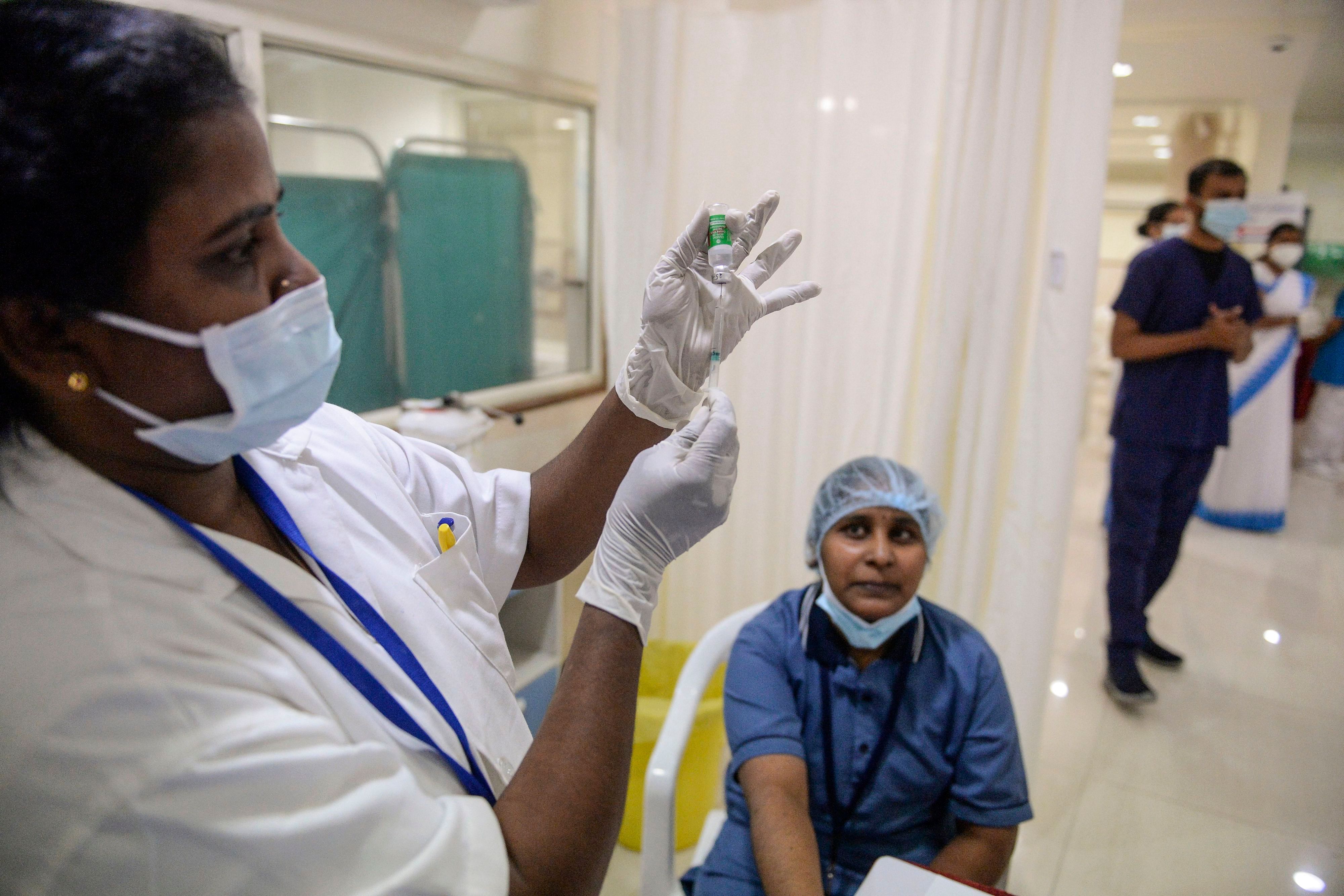 A health worker (L) prepares to inoculates a frontline staff with a Covid-19 vaccine at the KIMS hospital in Hyderabad on January 25, 2021. Credit: AFP Photo