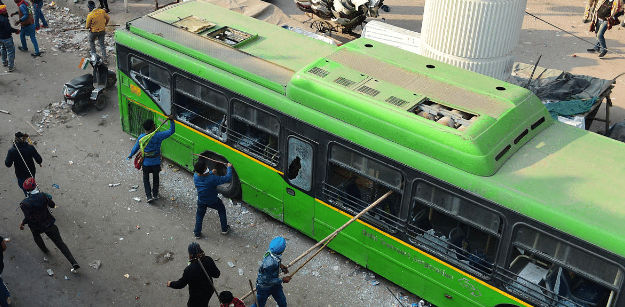Protesting farmers damage a bus during their clashes with security personnel, in New Delhi. Credit: PTI Photo